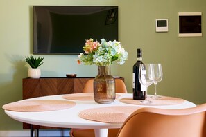 A dining table with placemats, a vase with flowers, a bottle, and glasses. - Apartment 'Casa Mimma' with Private Terrace, Wi-Fi and Air Conditioning (Terni)
