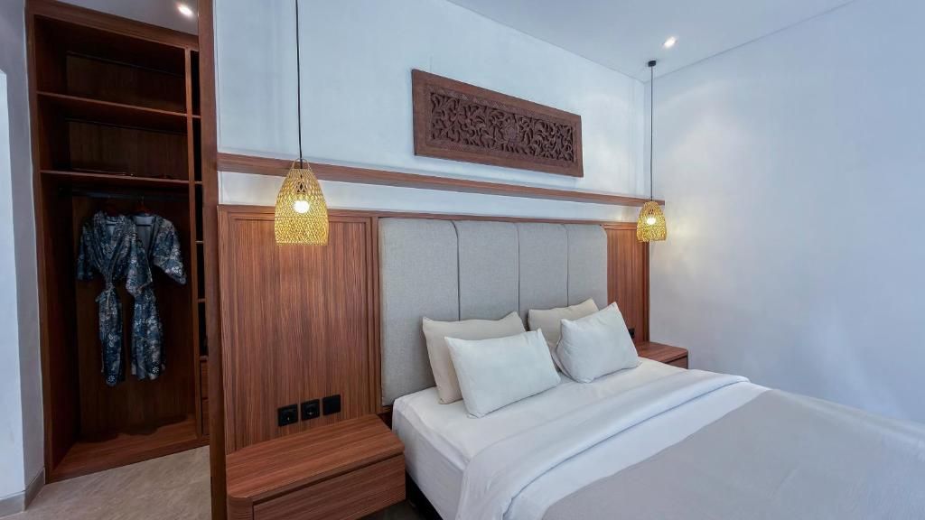 A bedroom with a bed, bedside tables, a wardrobe, and hanging lights.