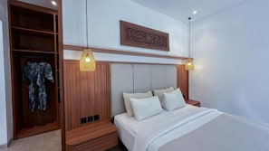 Quarto com cama, mesas de cabeceira, guarda-roupa e luminárias pendentes.