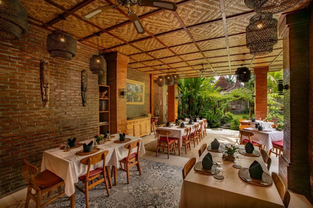 Un espace de restauration intérieur avec des murs en briques, des tables en bois et des lanternes suspendues.