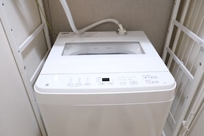 A white laundry machine with a control panel and a water inlet hose. - New Listing (板橋区)