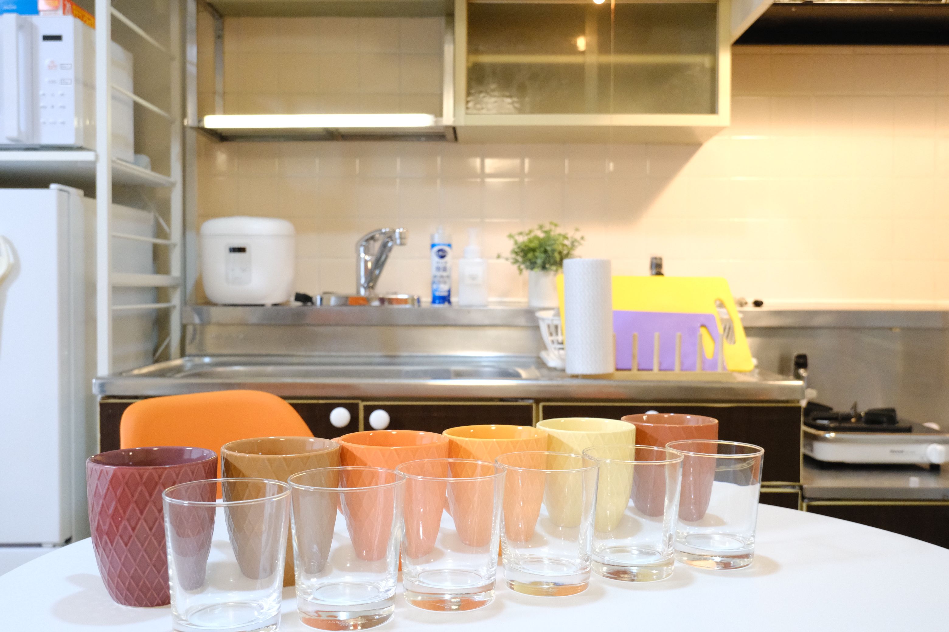 A kitchen with a sink, faucet, and various items on the counter.