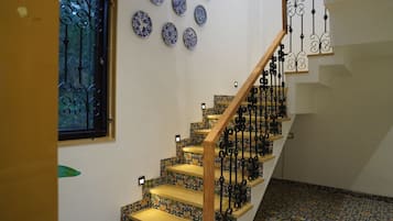 Uma escadaria com grades pretas elaboradas e piso estampado.