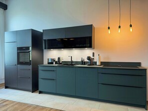 A modern kitchen with a built-in oven, a coffee maker, and a kettle. - Apartment in a Historic Hallenhaus on Butjadingen (Butjadingen)
