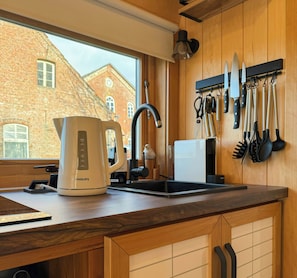 A kitchen with a kettle, a sink, and a knife rack. - Tiny House with a view by the Wadden Sea (Butjadingen)