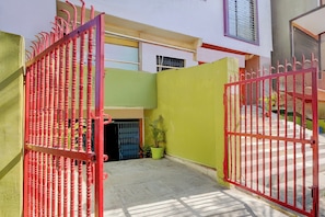 Un patio amurallado con un muro verde y una planta en maceta.