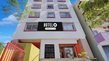 En hotellbyggnad med en skylt som visar att den tillhör kedjan OYO-Serviced.