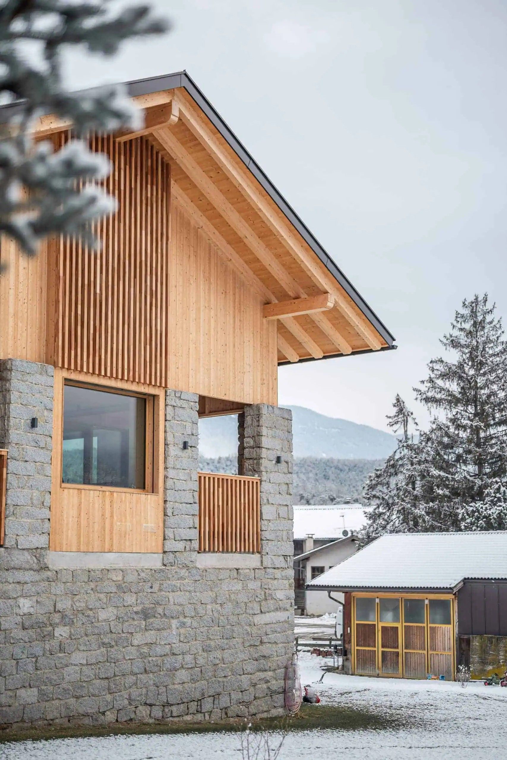 Un edificio moderno con fachada de piedra y listones de madera.
