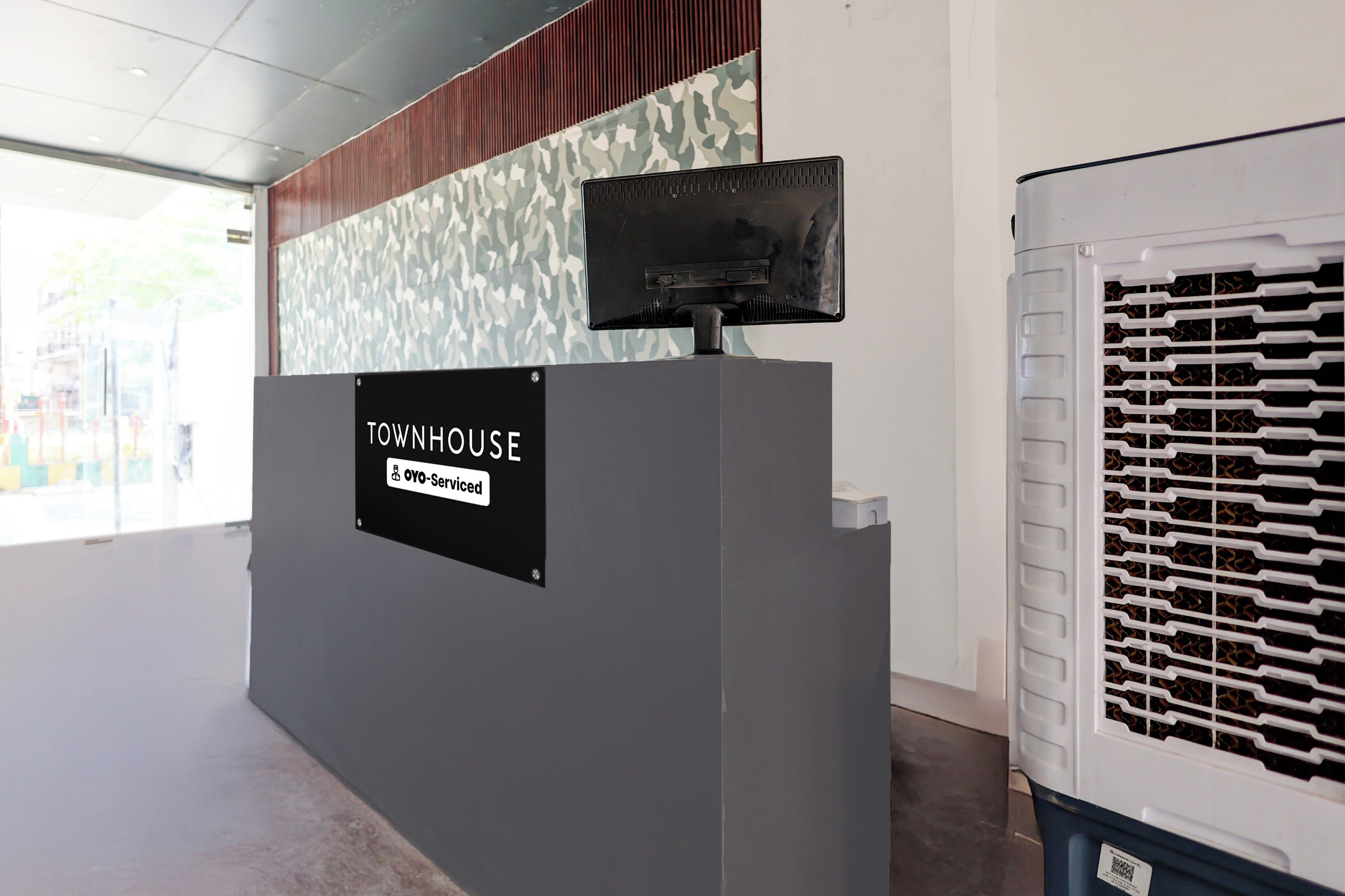 Una recepción con un cartel que dice 'TOWNHOUSE OYO-Serviced'.
