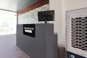 Una taquilla de recepció amb un cartell que diu 'TOWNHOUSE OYO-Serviced'.