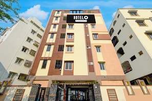 A multi-story hotel building with a sign indicating it is company-serviced.