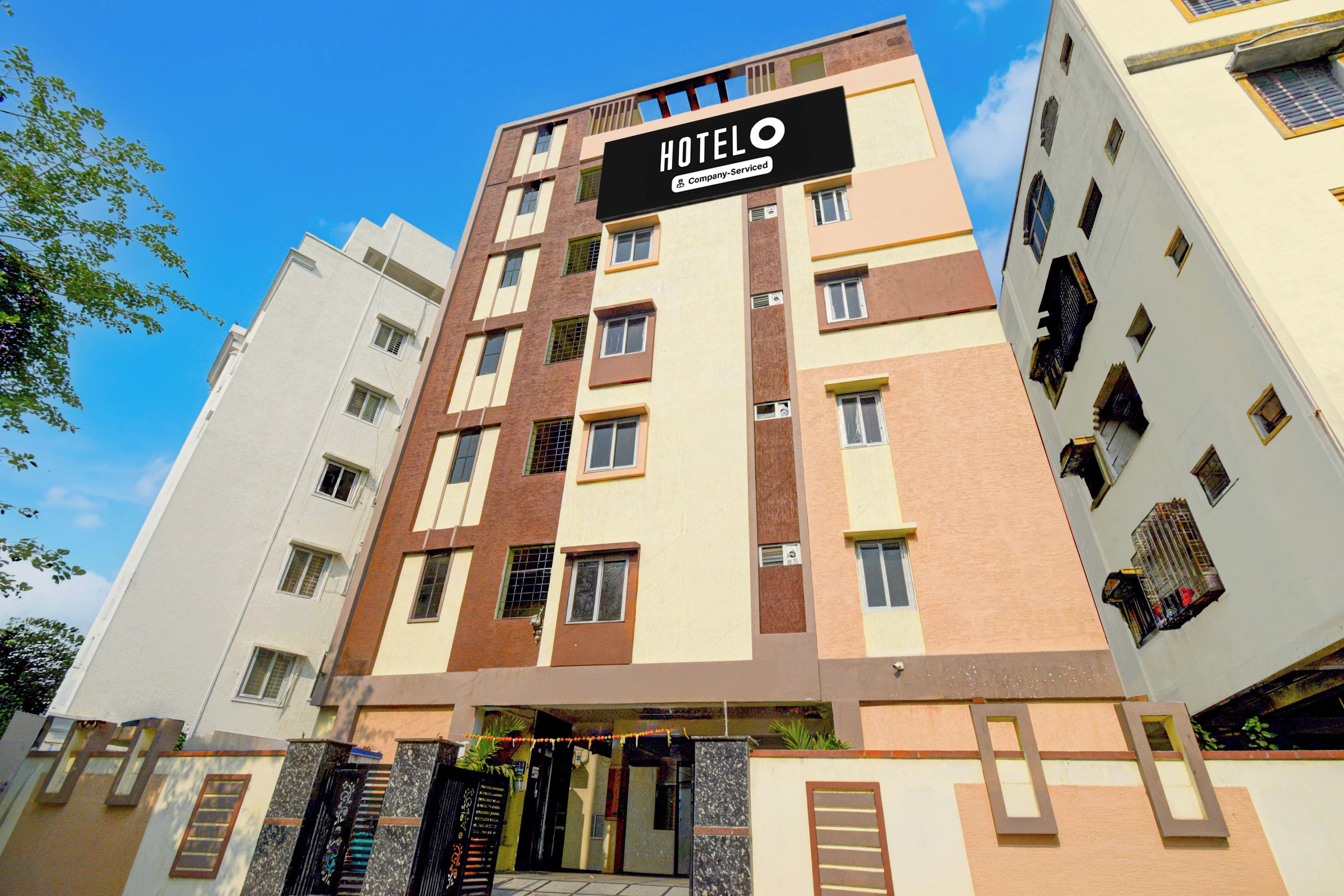 A multi-story hotel building with a prominent 'HOTEL' sign, featuring a company-serviced logo.
