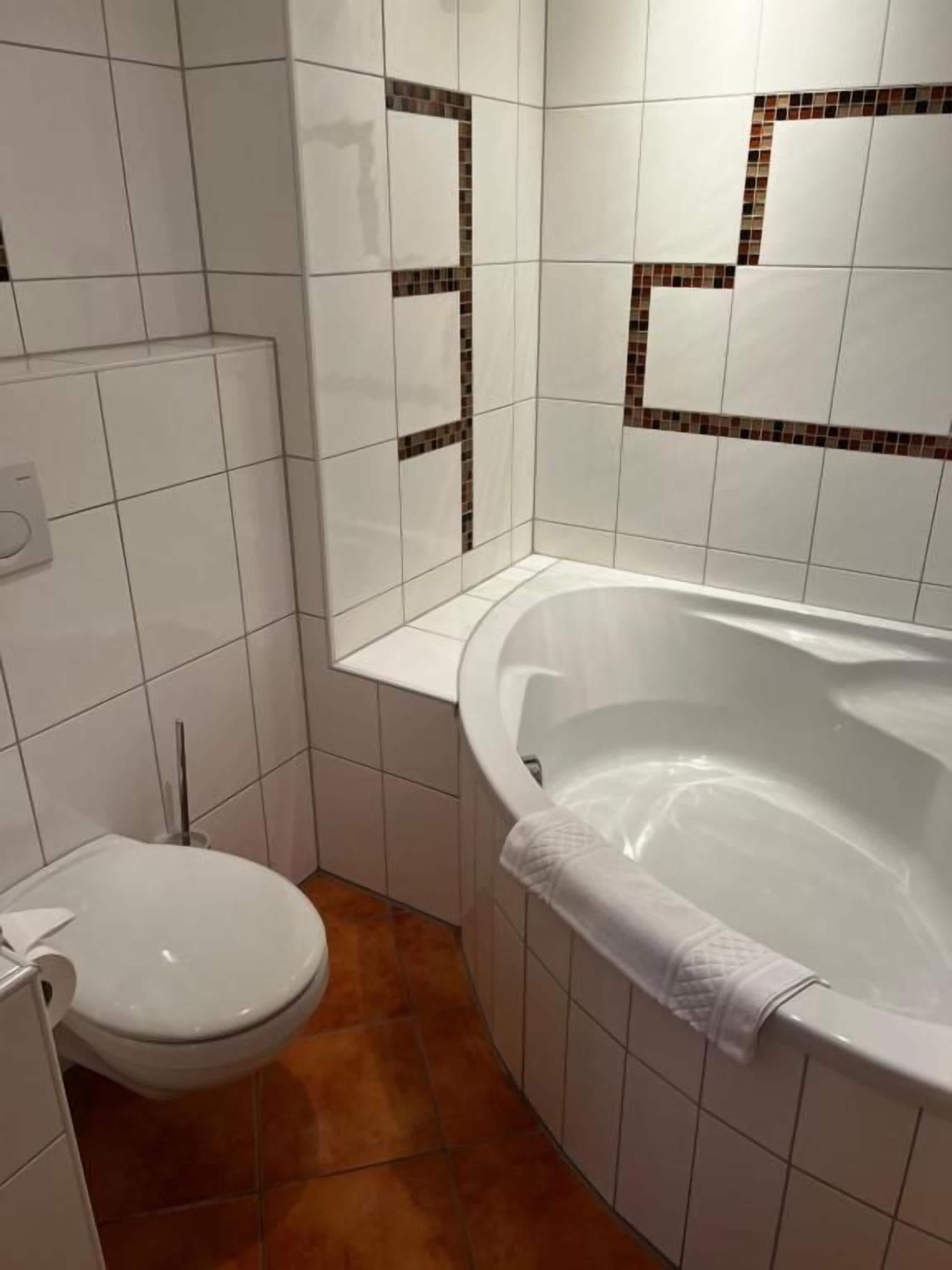 Ein Badezimmer mit einer weißen Badewanne, einer Toilette und einer Duschkabine.
