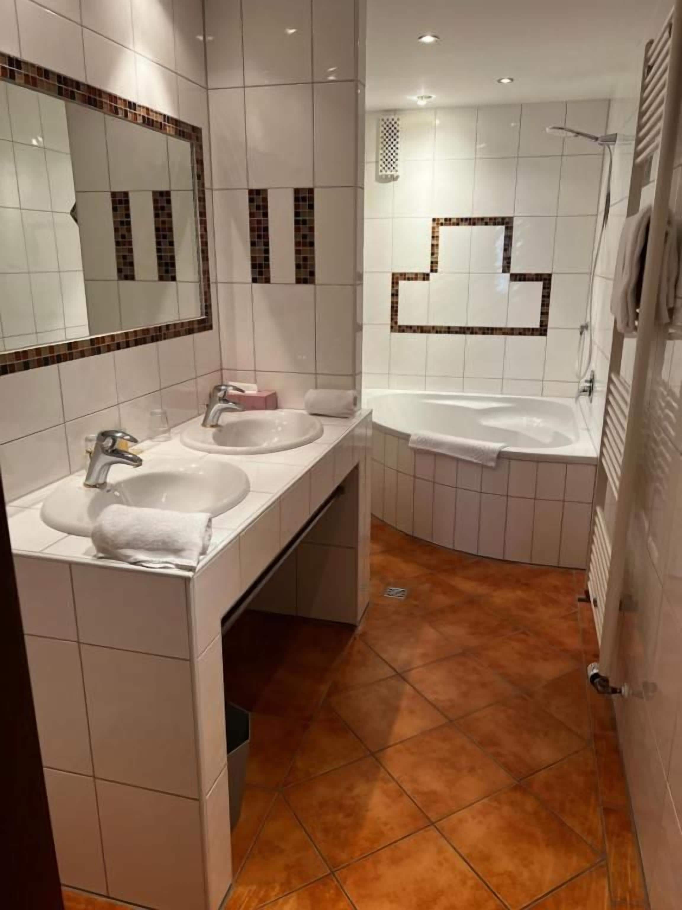 Ein Badezimmer mit zwei Waschbecken, einer Dusche und einem Spiegel.
