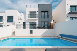 A modern building with a swimming pool, outdoor seating, and a staircase leading to the upper floors. - Silver Villa with private pool and sea view (Atalaia)