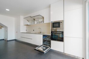 A modern kitchen with white cabinetry, a built-in microwave, oven, and dishwasher. - Silver Villa with private pool and sea view (Atalaia)