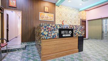 A reception desk with a sign reading 'HOTEL' and 'YO-Serviced'.
