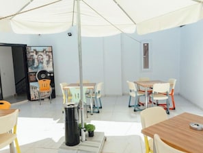 Une pièce avec des tables et des chaises, une poubelle et une affiche accrochée au mur.