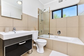 A modern bathroom with a bathtub, a toilet, and a sink. - Tee Off & Unwind at Jackal Creek by ctha (Roodepoort)