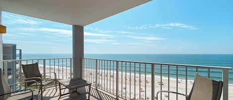 A balcony with a view of the beach and ocean.