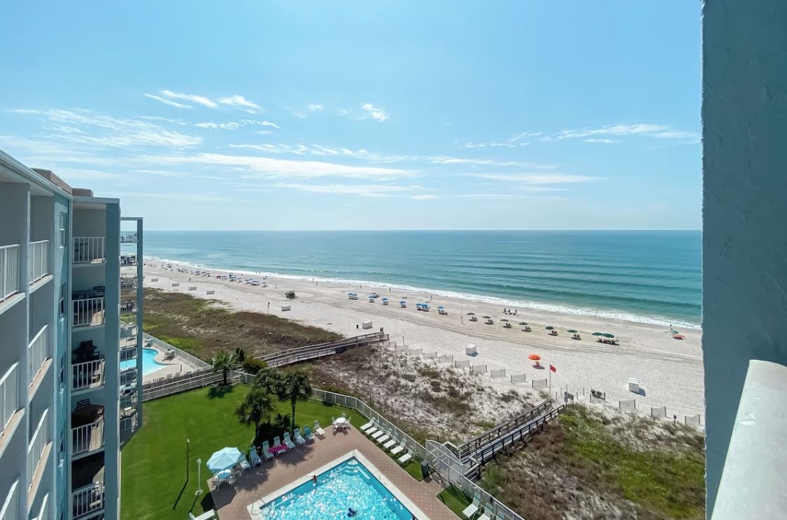 A beachfront hotel with a pool, beach access, and a view of the ocean.