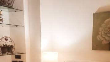 A hotel room with a bed, a lamp, and a wall-mounted artwork.