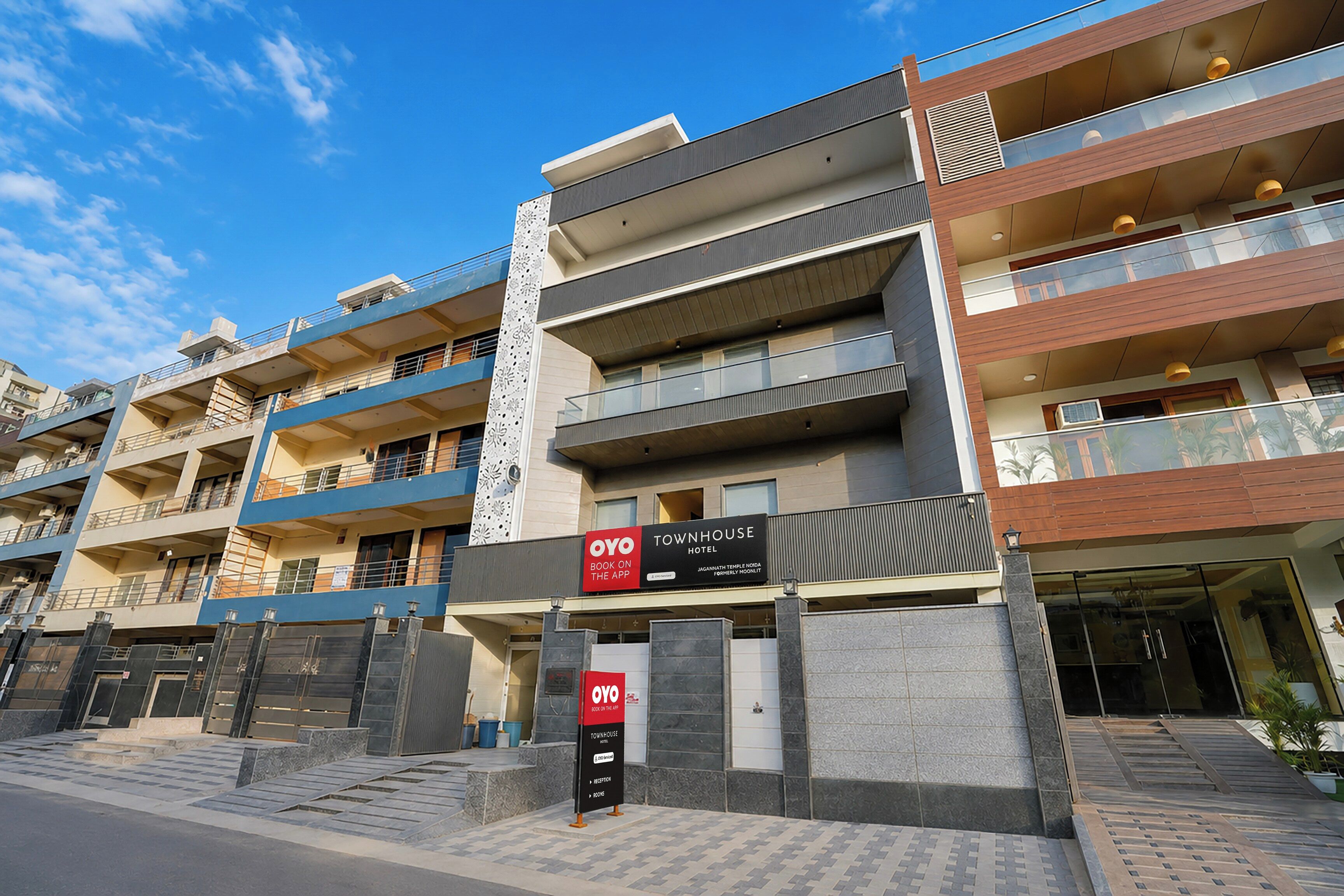 A multi-story hotel with a modern design, featuring balconies and a prominent sign for the OYO Townhouse Hotel.