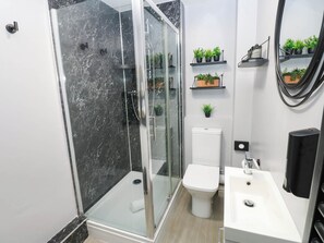 A modern bathroom with a glass-enclosed shower, a toilet, and a sink. - Sands Green (Appleby-in-Westmorland)