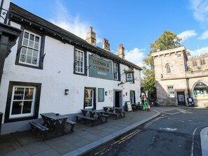 A traditional pub named 'Crow & Cushion' with outdoor seating and a stone building in the background. - Sands Green (Appleby-in-Westmorland)