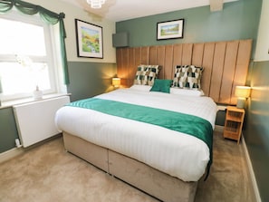 A bedroom with a bed, two bedside lamps, a window with curtains, and two framed pictures on the wall. - Sands Green (Appleby-in-Westmorland)