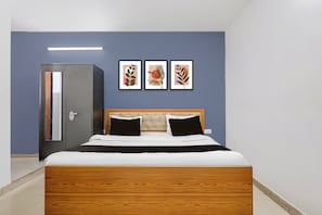 Un dormitorio con cama, armario y tres cuadros en la pared.
