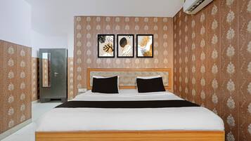 Un dormitorio con cama, armario y tres cuadros en la pared.