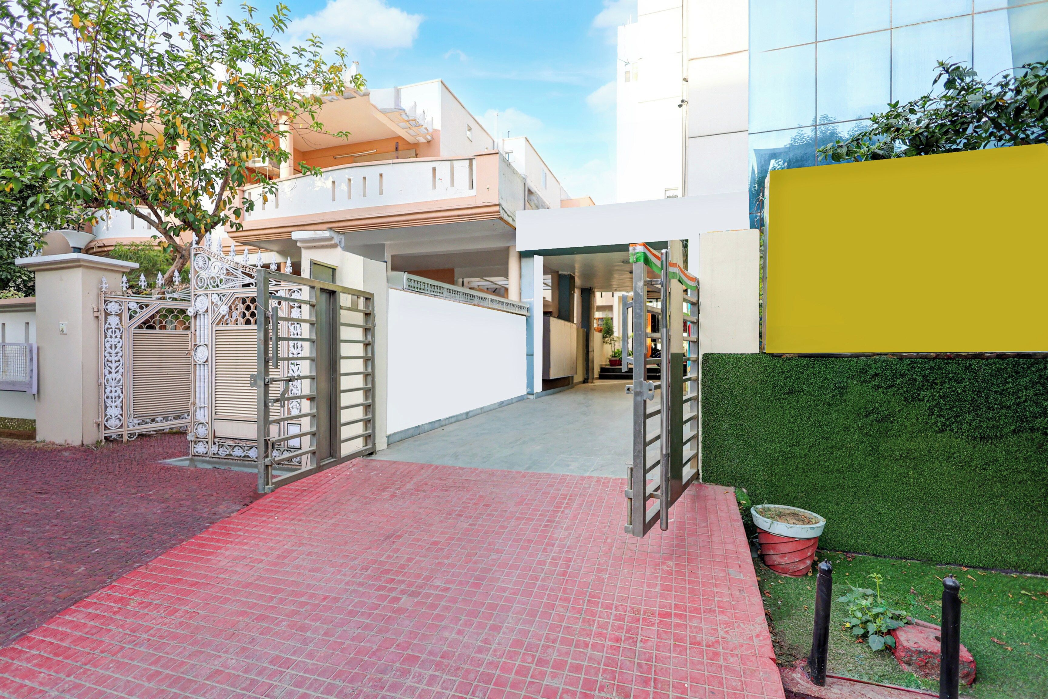 Una entrada con acceso restringido y un sendero de ladrillo rojo que lleva a un edificio de diseño moderno.