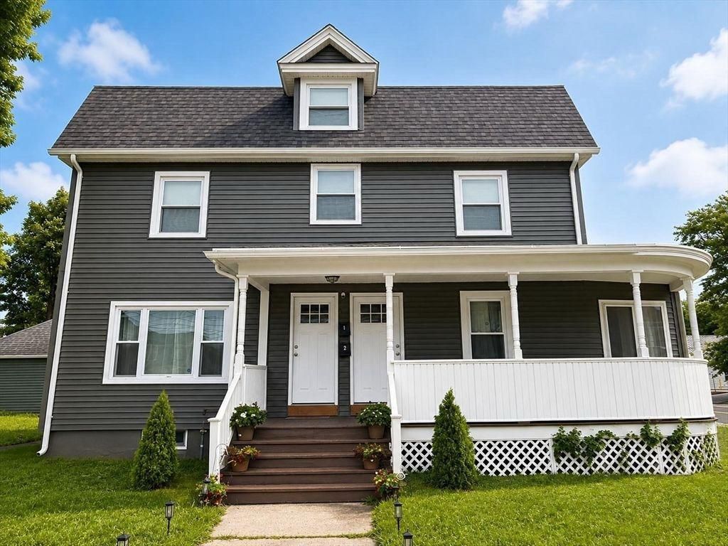 A two-story house with a front porch, a small entryway, and a set of stairs leading to the front door.