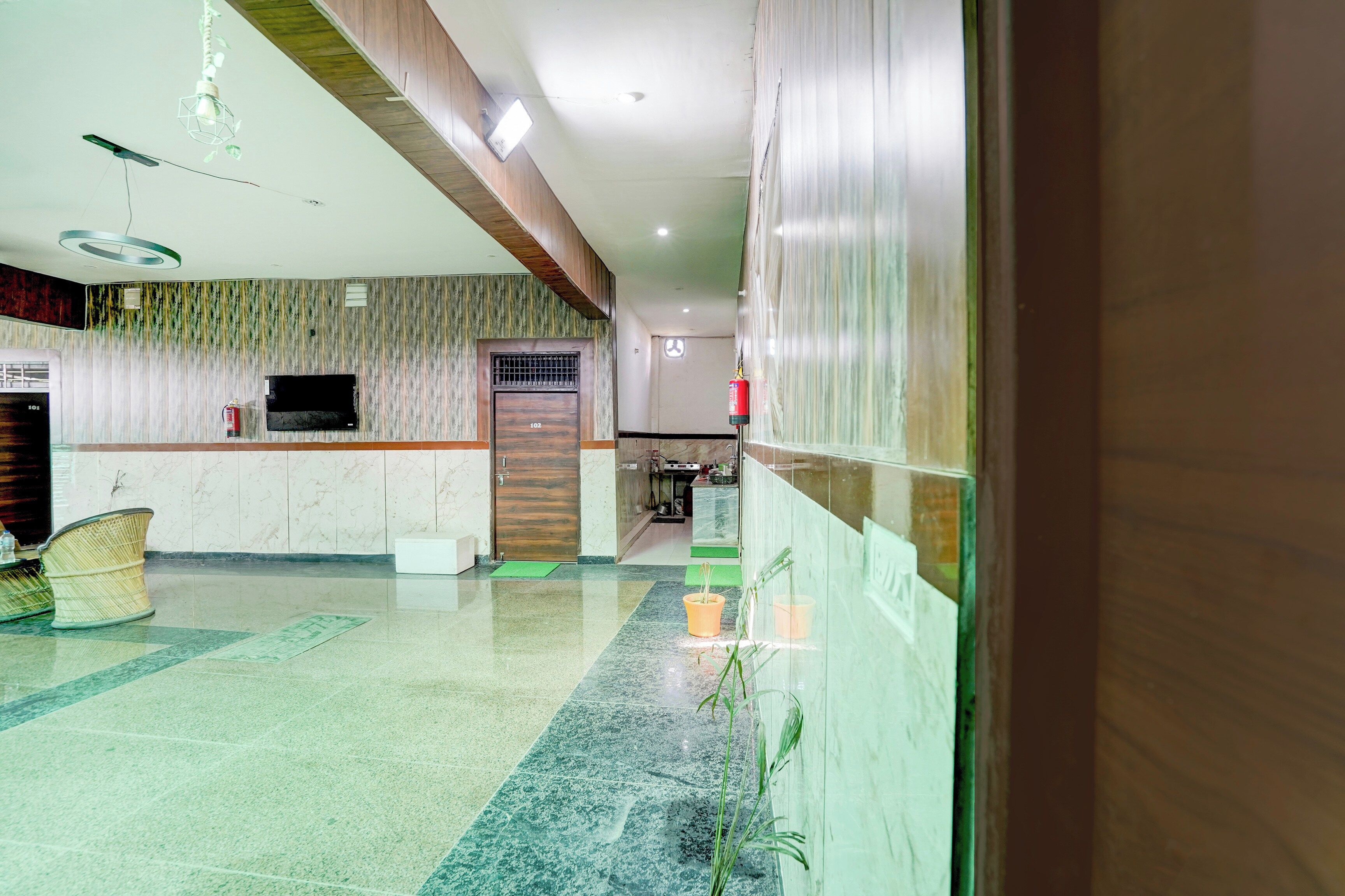 Eine Hotelhalle mit einer Rezeption, einer Sitzecke und einer Küche im Hintergrund.