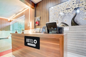Balcão de recepção de hotel com indicação de serviço empresarial.