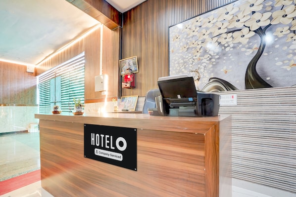Una recepción de hotel con un letrero que indica servicio de empresa.
