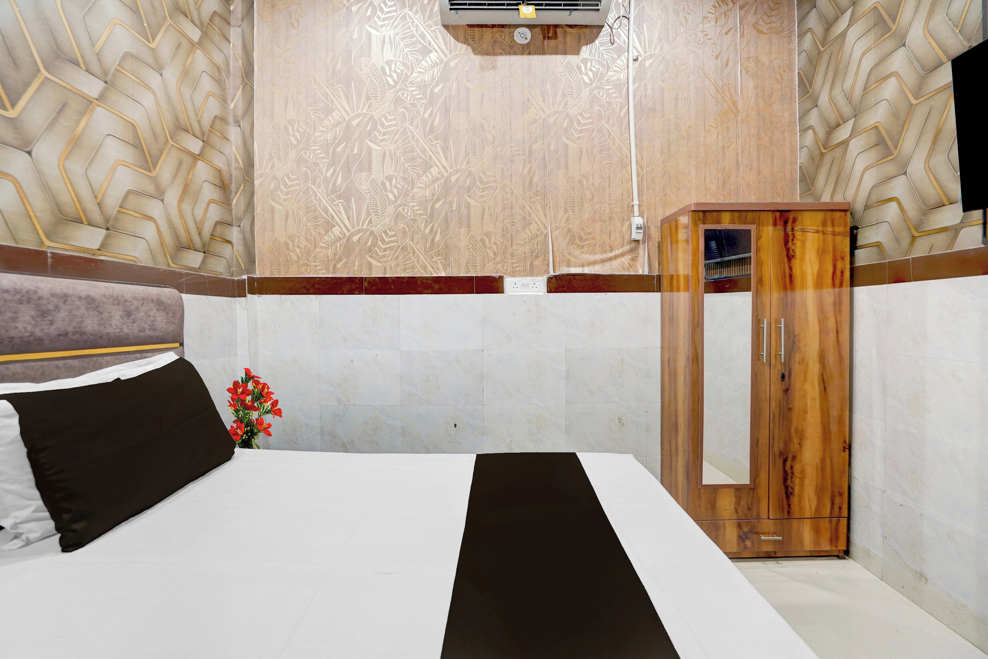 Ein Hotelzimmer mit einem Bett, einem Holzschrank und einer Dekoration an der Wand.