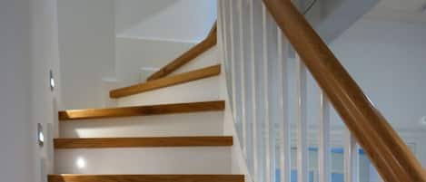 Una escalera con barandillas de madera y paredes blancas.