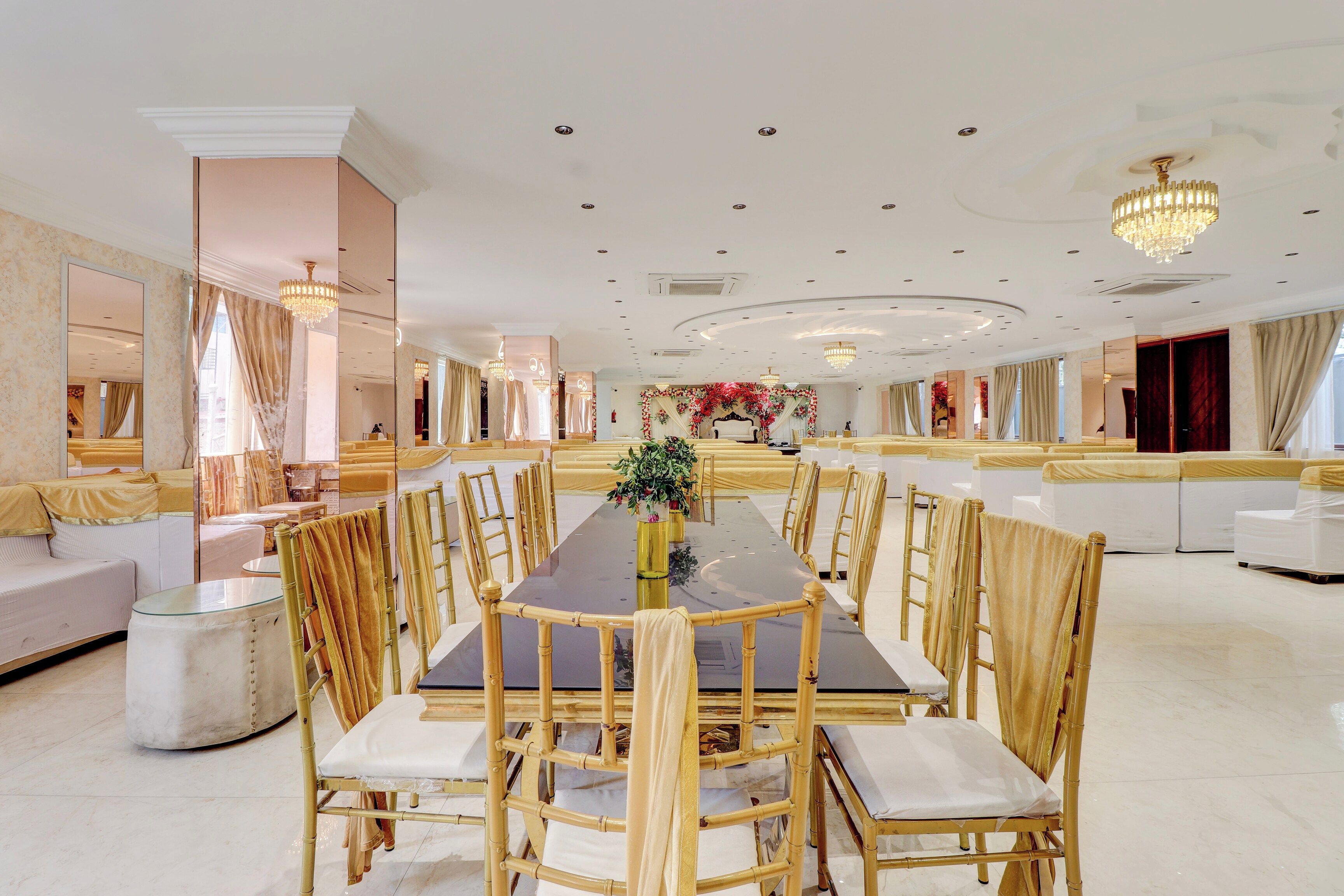 Un comedor espacioso con una larga mesa, numerosas sillas y un arreglo floral central.