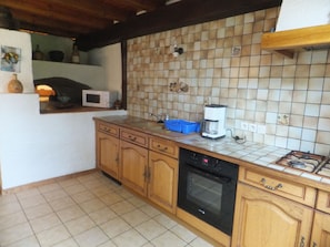 A kitchen with wooden cabinets, a microwave, a coffee maker, and a tiled backsplash. - New Listing (Desseling)