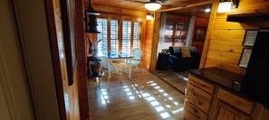 A wooden interior with a dining area, a sofa, and a kitchen counter. - Apartment with a Peaceful Cabin Feel and Coosawattee River Resort Amenities (Ellijay)