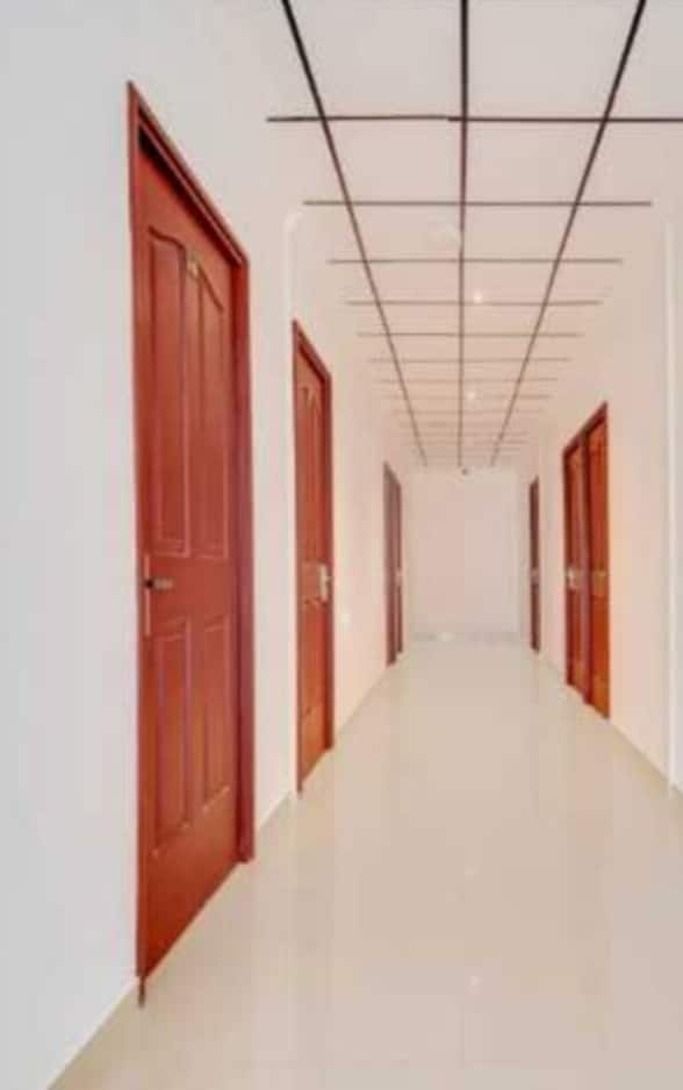 Corredor com portas de madeira e chão de azulejos.