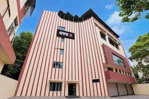 A hotel building with a vertical striped facade, a prominent sign, and a flat roof.