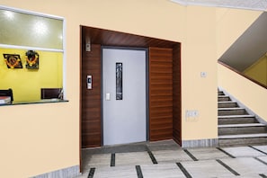 A reception area with a counter, a door, and a staircase.