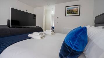 Een hotelkamer met een bed, een flatscreen televisie, een ingelijst kunstwerk aan de muur en een raam.