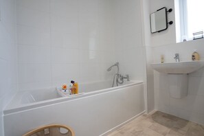 A modern bathroom with a bathtub, a sink, and a mirror. - Peak Avenue Retreat - Dog Friendly with Garden! (Derbyshire)