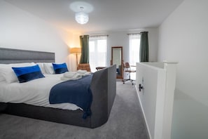 A hotel room with a large bed, a desk, and a chair. - Peak Avenue Retreat - Dog Friendly with Garden! (Derbyshire)