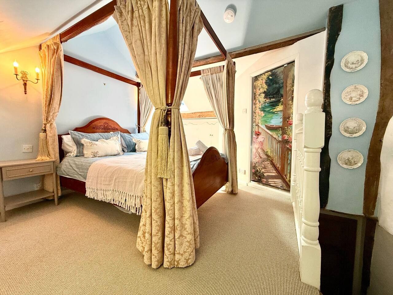 A bedroom with a four-poster bed, a nightstand, and a view of a garden through a window.