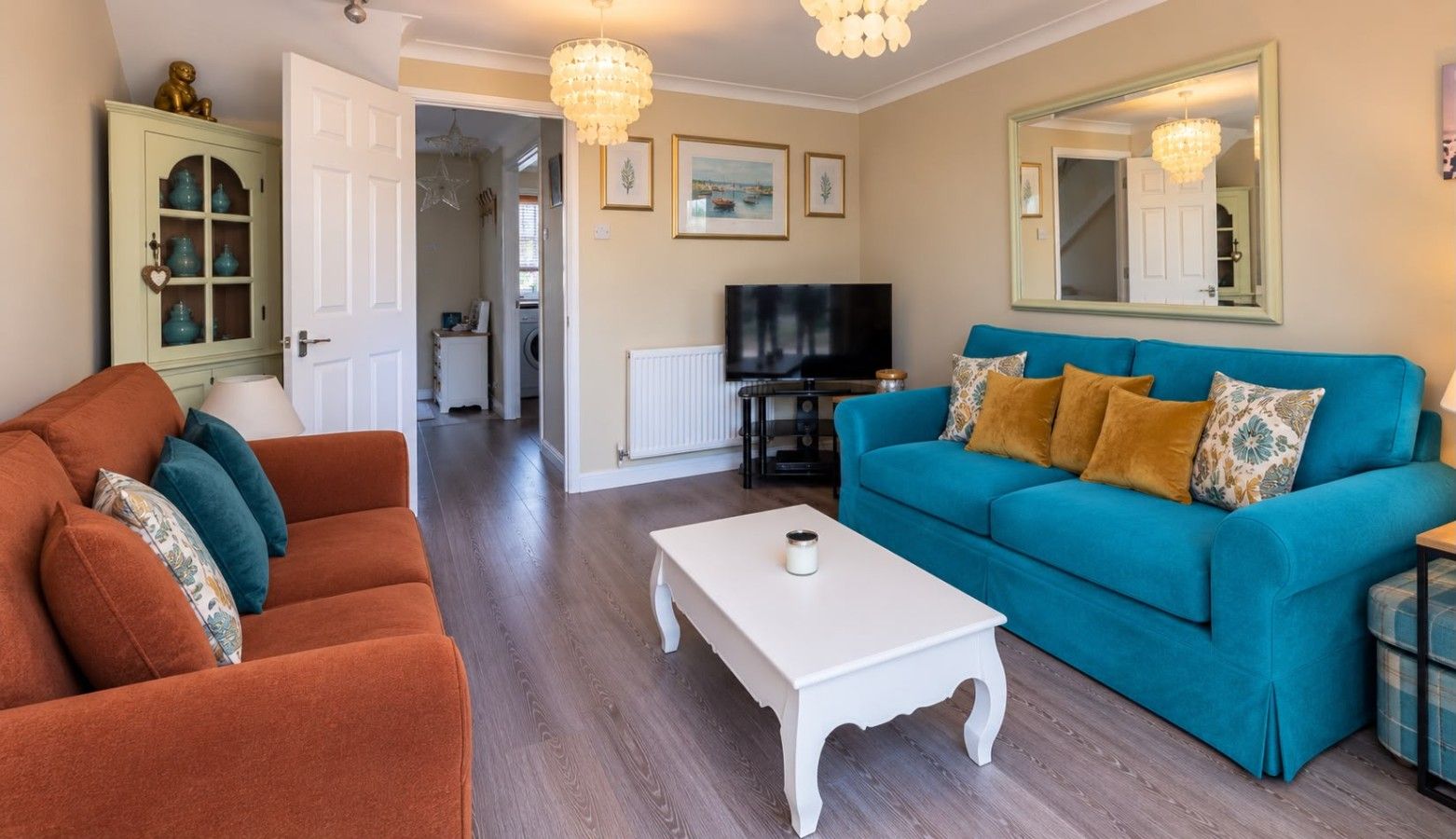 A living room with a sofa, a coffee table, and a television.
